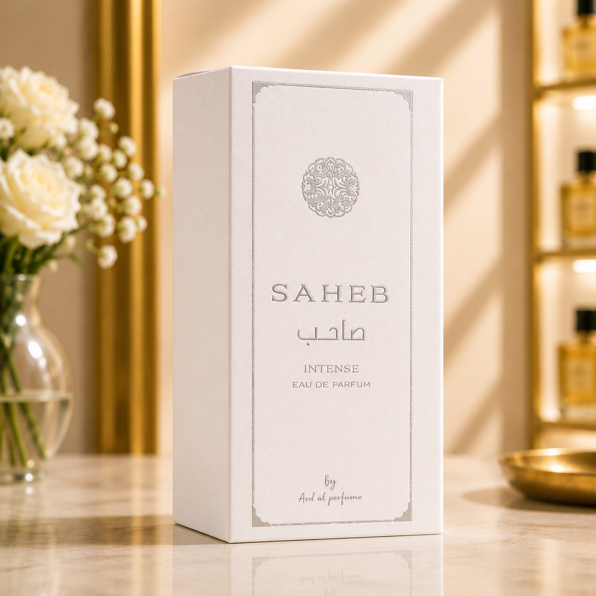 Boîte du parfum Saheb Intense Eau de Parfum présentée sur un fond premium en marbre avec décoration dorée.